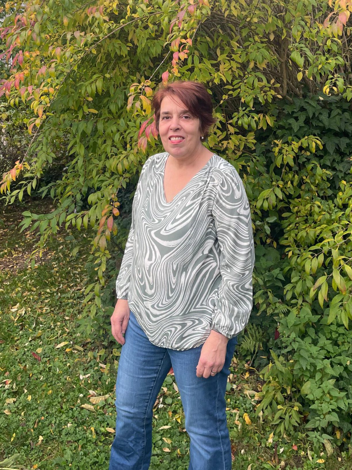 Sonja Blaut steht selbstbewusst im herbstlichen Garten.